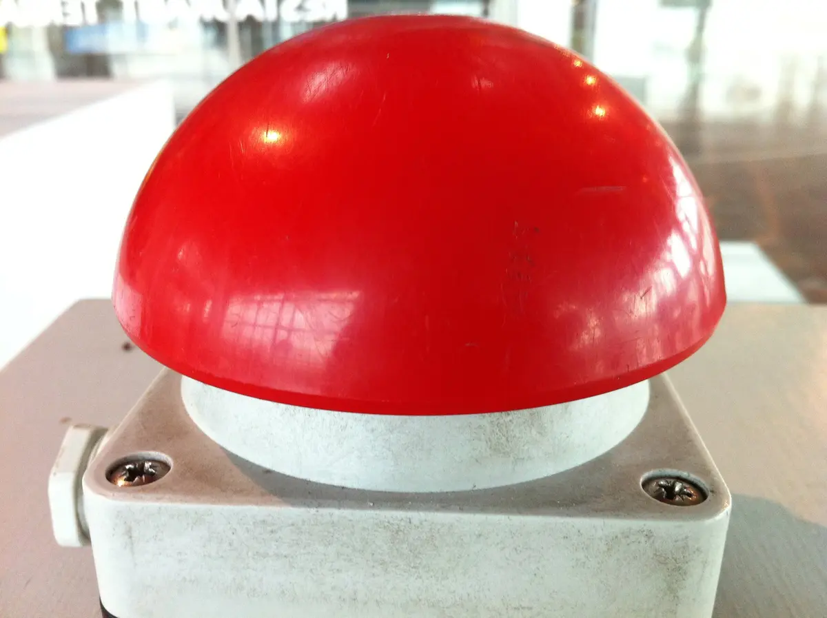Großer roter Druckknopf auf einem grauen Gehäuse