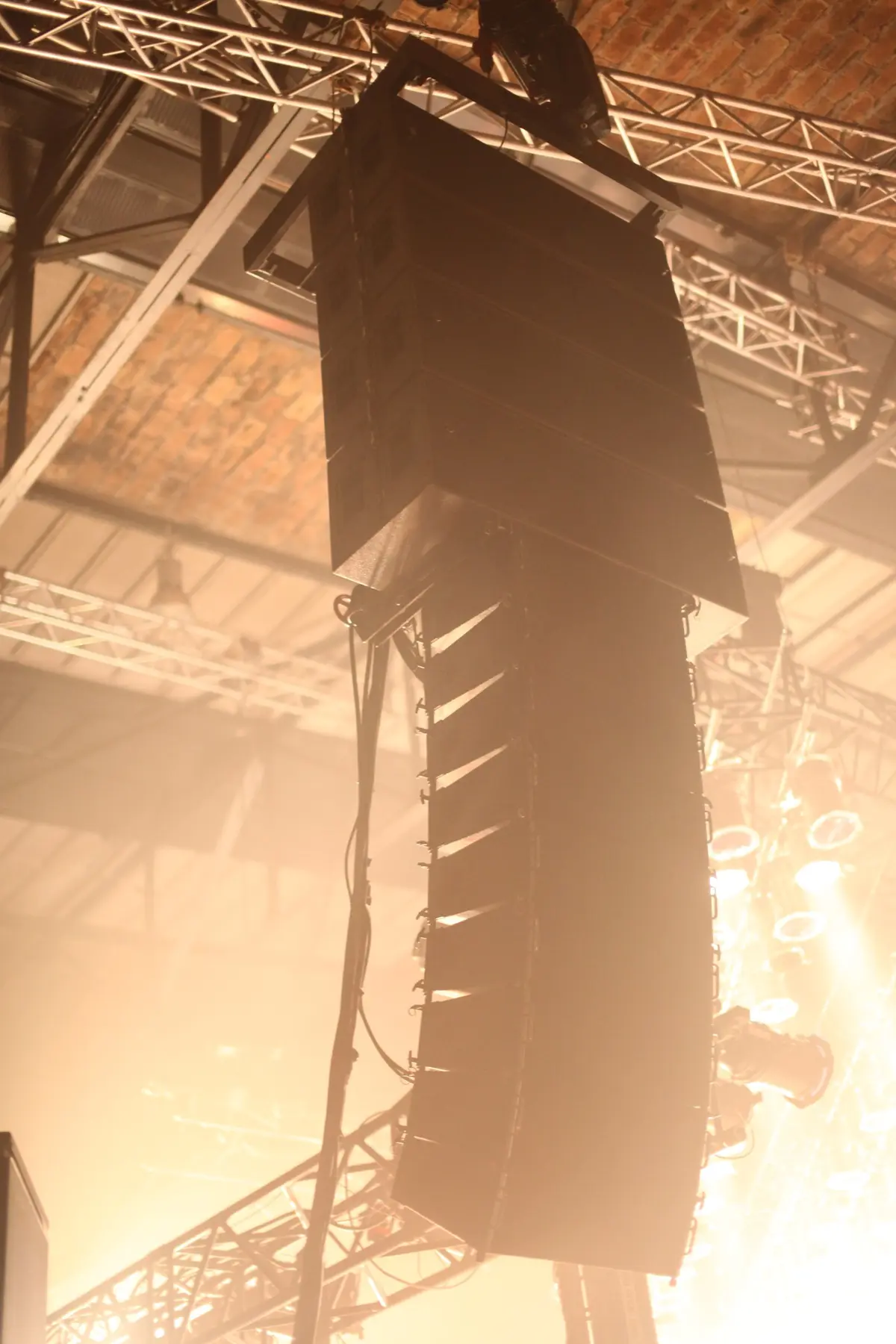 Line-Array-Lautsprecher hängen im Gegenlicht unter einer Traverse